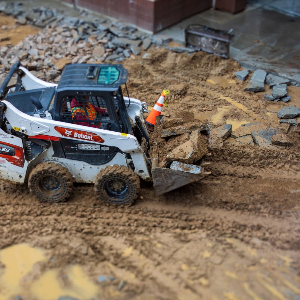 A track loader moving rock across a site