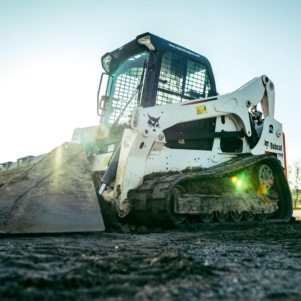 A compact track loader working on a site