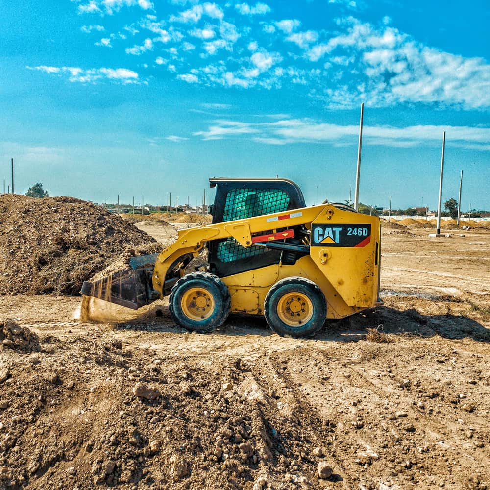 A skid steer loader working exposed ground