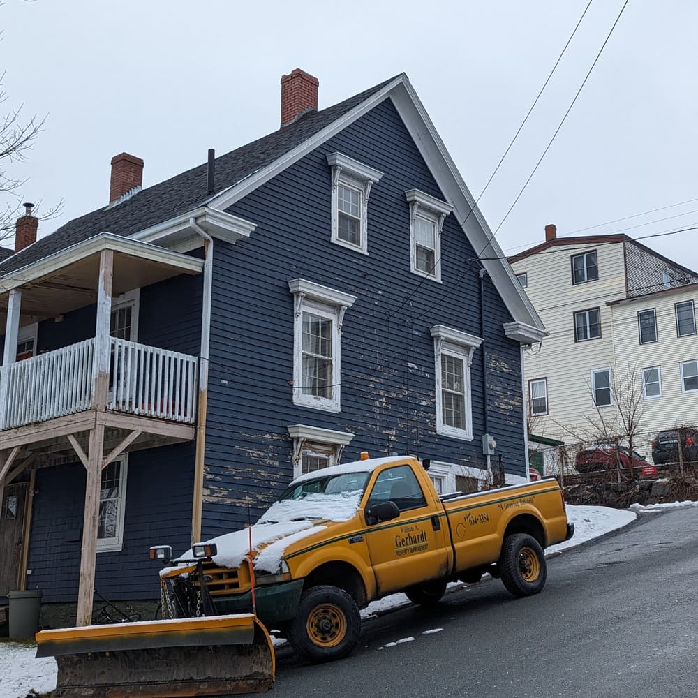 A pickup truck fitted with a snow plow blade on a winter street