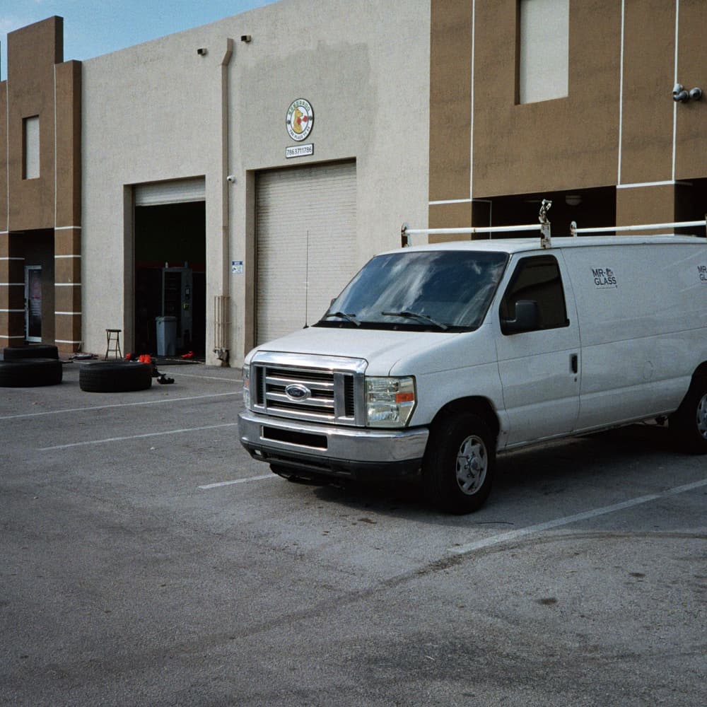 A white work van parked outside a trade workshop